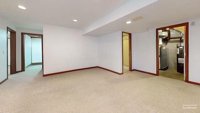 additional living space with carpet flooring, baseboards, and electric water heater