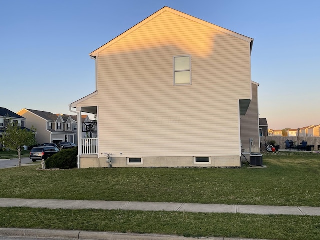 view of side of property featuring cooling unit and a lawn