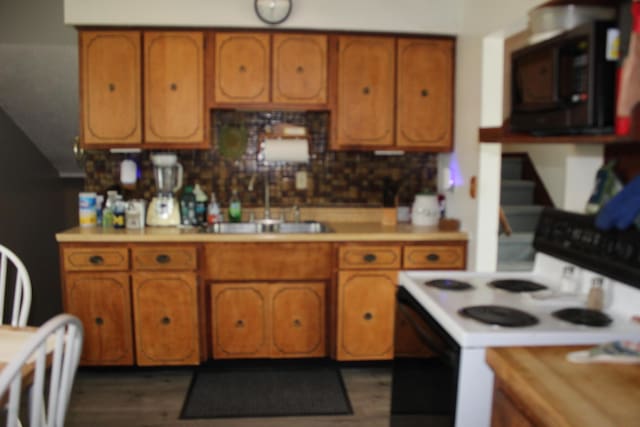 kitchen with black microwave, brown cabinets, and electric range