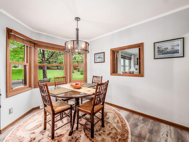 4159 Rowanne Rd, Columbus, OH 43214 - dining area with baseboards, a chandelier, crown molding, and light wood-style floors
