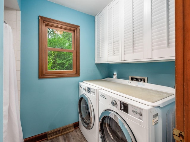 4159 Rowanne Rd, Columbus, OH 43214 - laundry area with washer and clothes dryer, baseboards, wood finished floors, and cabinet space