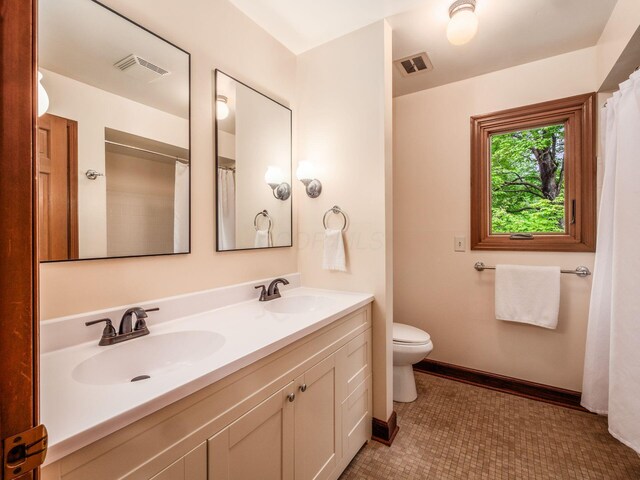 4159 Rowanne Rd, Columbus, OH 43214 - bathroom featuring toilet, double vanity, and tile patterned flooring