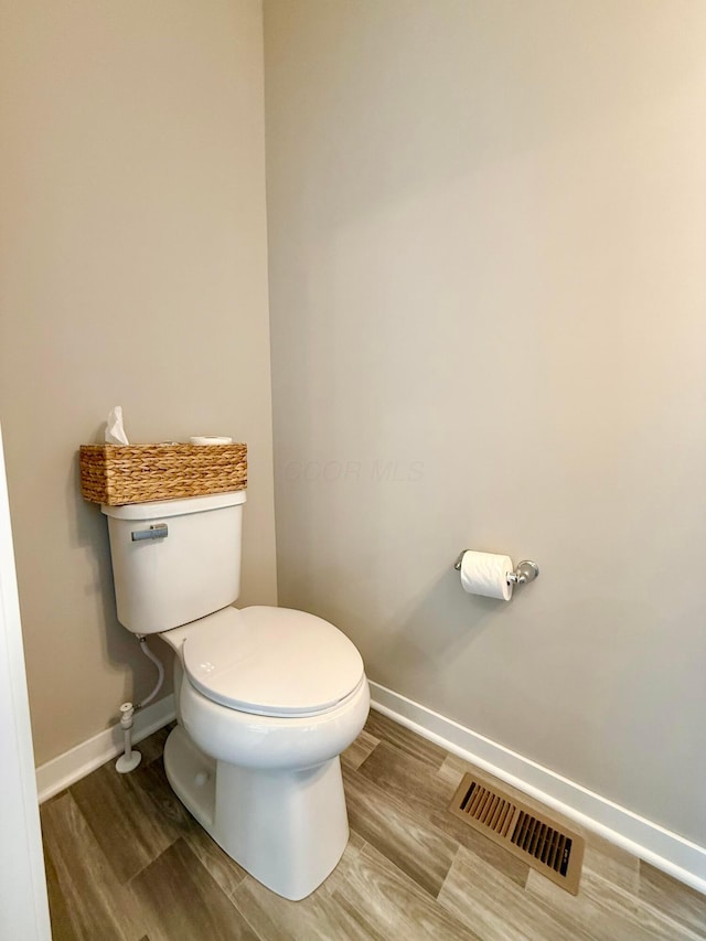 bathroom featuring wood finished floors, visible vents, toilet, and baseboards