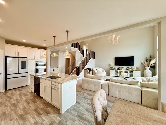 kitchen featuring smart refrigerator, a sink, light wood-type flooring, white cabinets, and black dishwasher