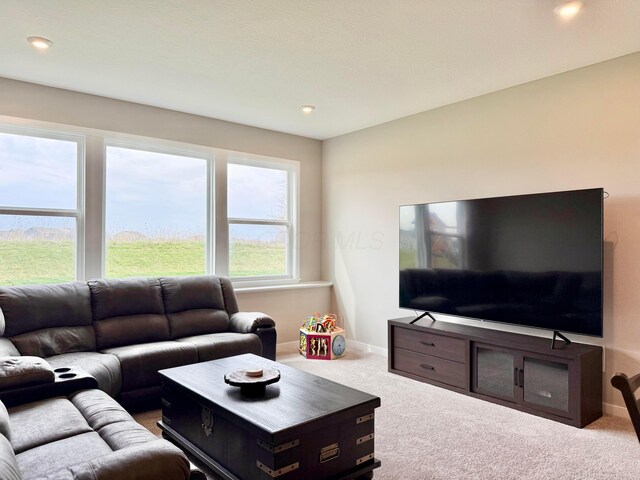carpeted living area with recessed lighting and baseboards