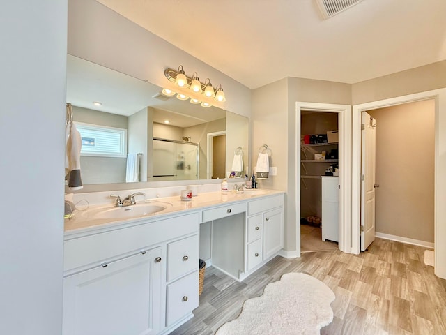 full bath featuring wood finished floors, visible vents, a stall shower, and a sink