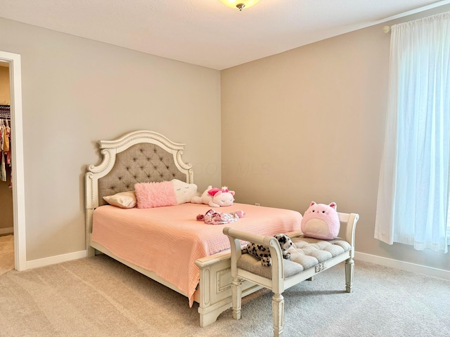 bedroom featuring light colored carpet and baseboards