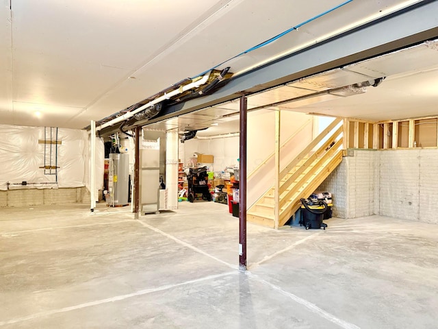 unfinished below grade area with stairway, brick wall, and water heater