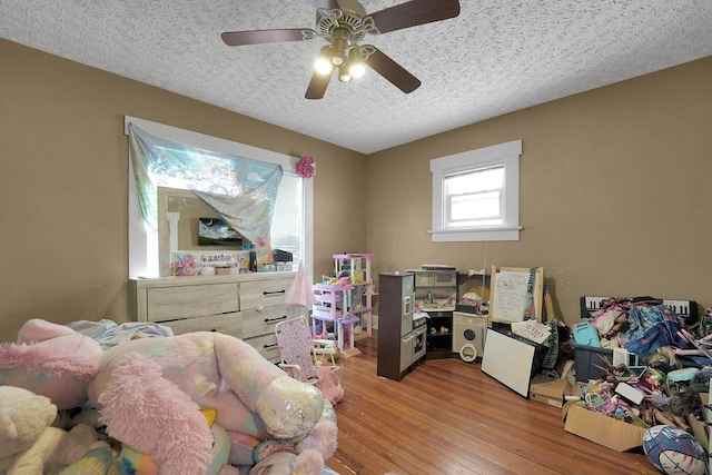 bedroom featuring wood finished floors, a textured ceiling, and ceiling fan