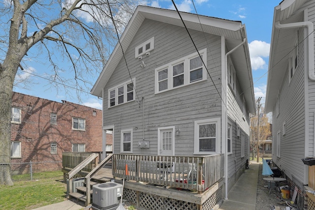rear view of property with fence, a deck, and cooling unit
