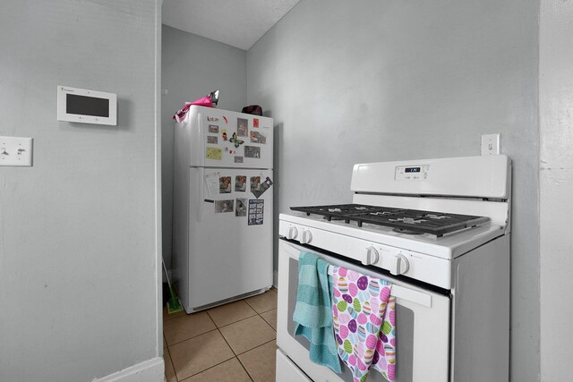 kitchen with light tile patterned floors and white appliances