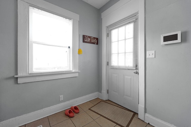 entryway featuring baseboards and light tile patterned floors