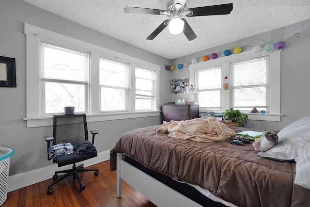 bedroom featuring baseboards, wood finished floors, a textured ceiling, and ceiling fan
