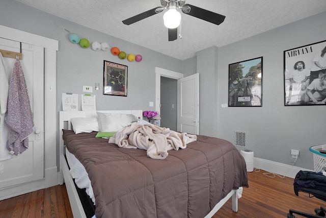 bedroom featuring wood finished floors, a textured ceiling, baseboards, and ceiling fan