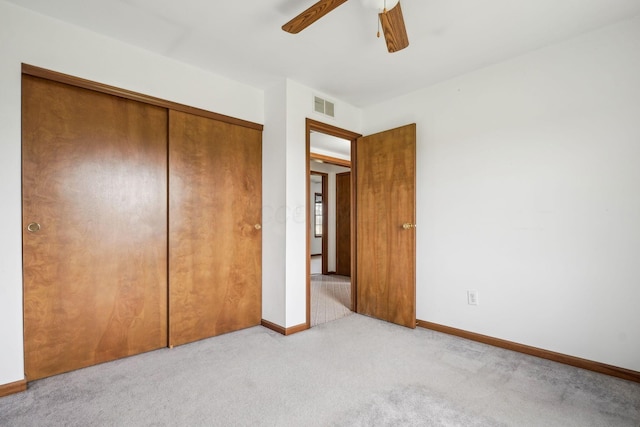 unfurnished bedroom featuring a ceiling fan, a closet, carpet floors, baseboards, and visible vents