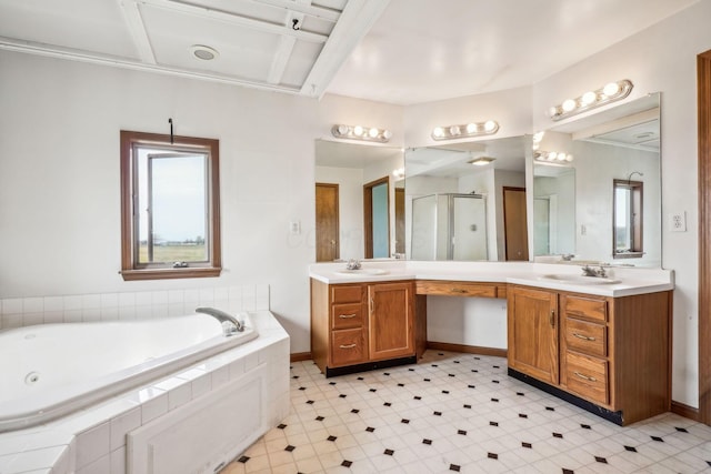 bathroom featuring a shower stall, a garden tub, vanity, and baseboards