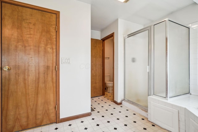full bathroom featuring tile patterned floors, baseboards, a shower stall, and toilet