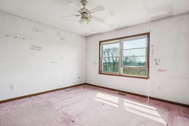carpeted spare room featuring ceiling fan, baseboards, and visible vents