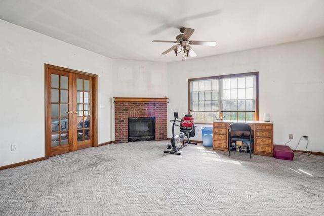 interior space featuring a brick fireplace, baseboards, ceiling fan, and french doors