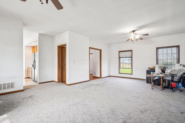 carpeted living area featuring visible vents, baseboards, and ceiling fan