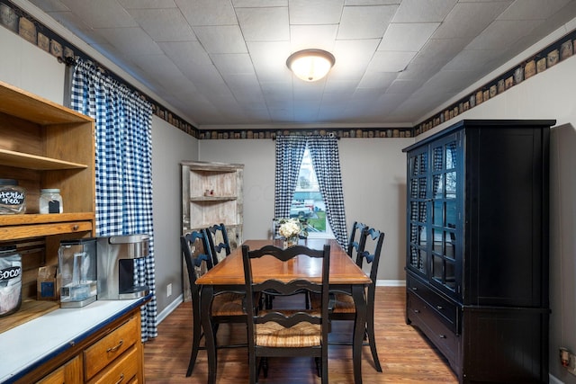 dining space with wood finished floors and baseboards