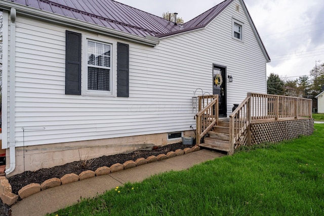 back of property featuring a yard, metal roof, and a deck