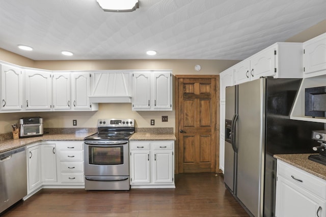 kitchen featuring premium range hood, appliances with stainless steel finishes, white cabinetry, and recessed lighting