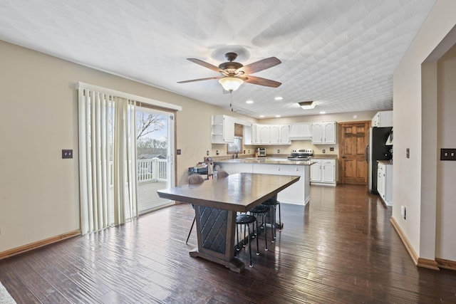 kitchen with white cabinets, baseboards, ceiling fan, and dark wood-style floors