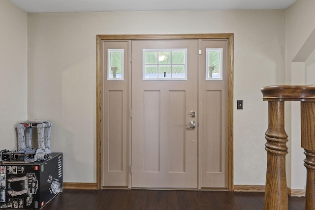 foyer featuring baseboards and dark wood-style floors