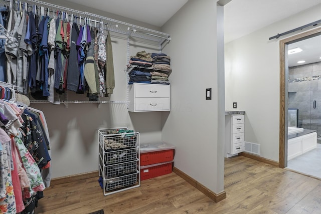 spacious closet featuring wood finished floors and visible vents