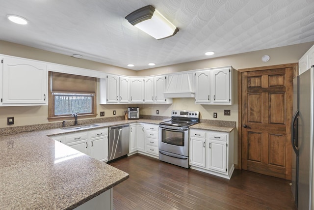kitchen featuring custom exhaust hood, a sink, stainless steel appliances, white cabinets, and recessed lighting