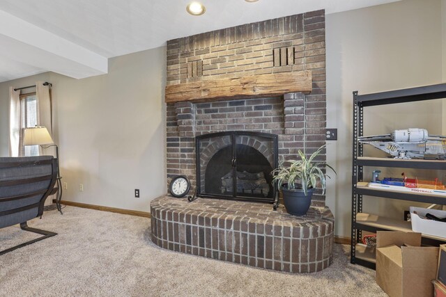 carpeted living room featuring baseboards and a brick fireplace