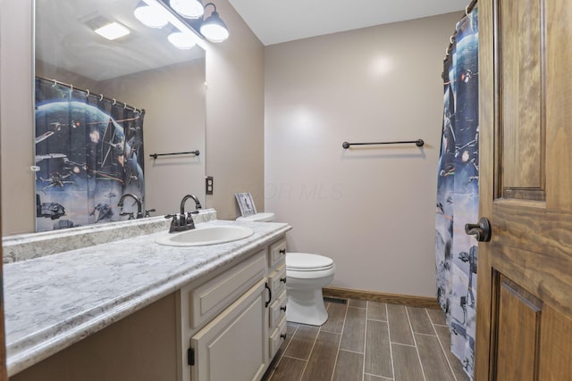 bathroom with toilet, baseboards, curtained shower, vanity, and wood finish floors