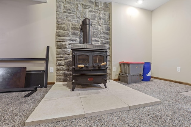 living room featuring baseboards, carpet, and a wood stove
