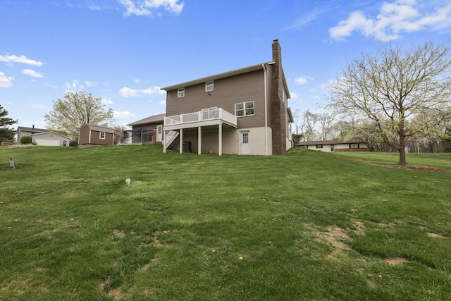 back of property with stairs, a yard, a chimney, and a deck