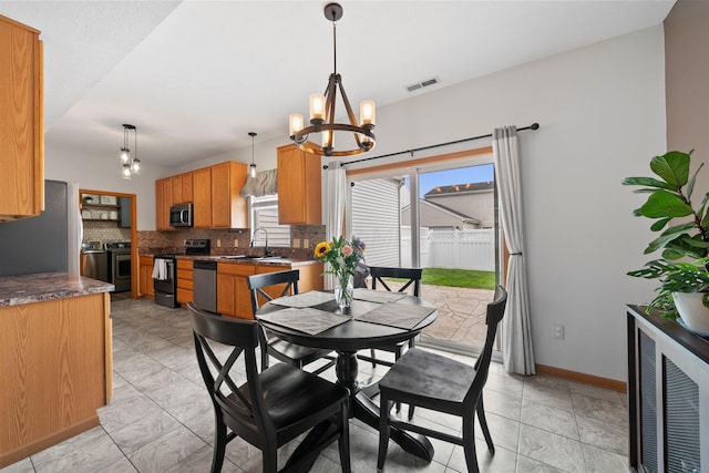 dining room featuring a chandelier, baseboards, and visible vents