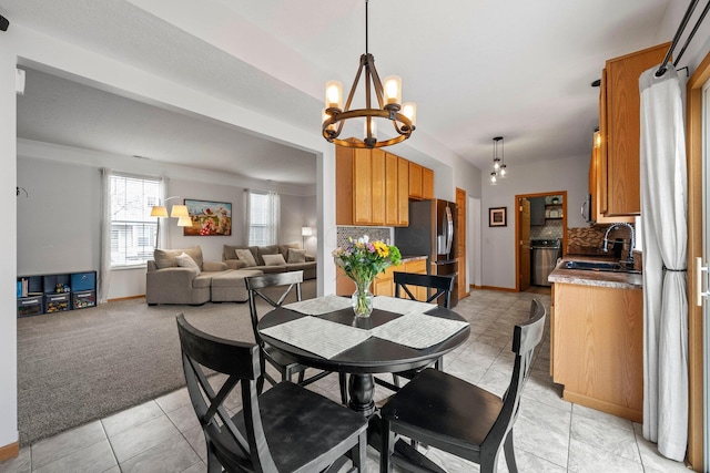dining room with baseboards, light carpet, and a notable chandelier