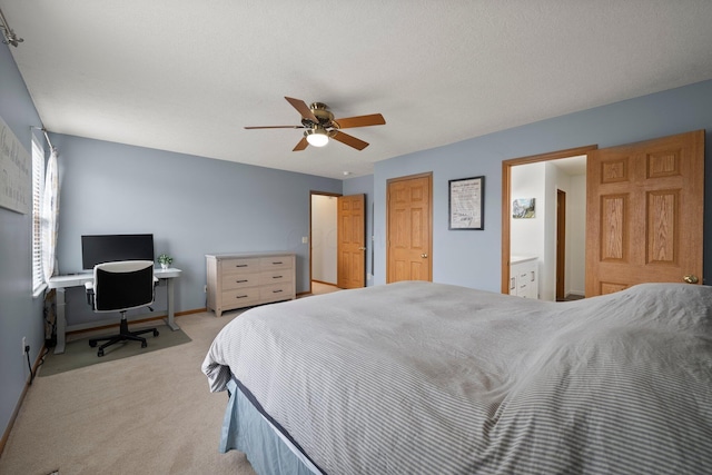 bedroom with light colored carpet, connected bathroom, baseboards, and ceiling fan
