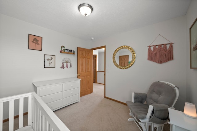 bedroom featuring light colored carpet, baseboards, and a crib