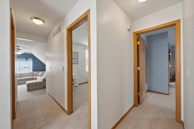corridor with visible vents, carpet, and baseboards