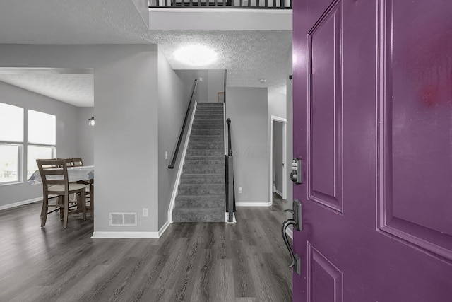 1065 Mastell Dr, Reynoldsburg, OH 43068 - foyer entrance with a textured ceiling, dark wood-type flooring, baseboards, and stairway