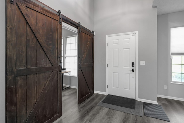 1065 Mastell Dr, Reynoldsburg, OH 43068 - foyer entrance with a barn door, dark wood finished floors, and baseboards