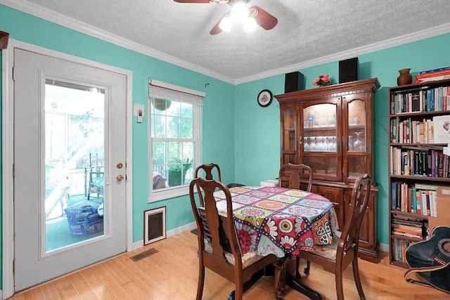 3161 Bowdoin Cir, Columbus, OH 43204 - dining room with a textured ceiling, light wood-style floors, ceiling fan, ornamental molding, and baseboards