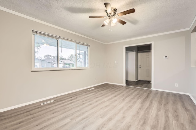 unfurnished bedroom featuring a textured ceiling, ornamental molding, wood finished floors, baseboards, and ceiling fan