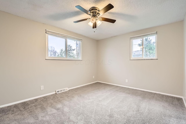 empty room featuring carpet, ceiling fan, baseboards, and a textured ceiling