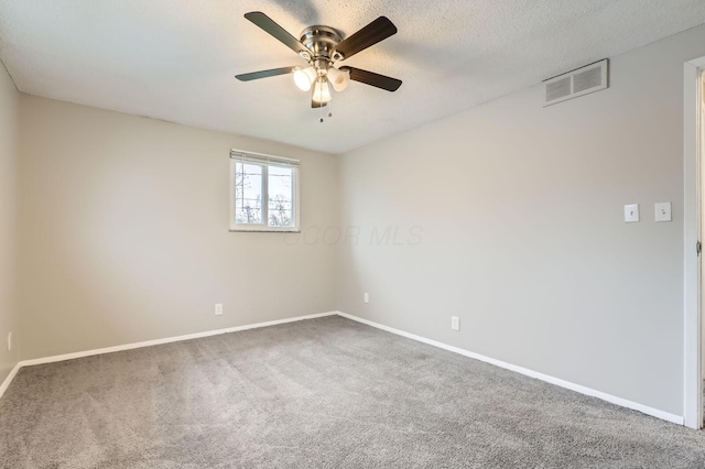 unfurnished room with carpet, ceiling fan, baseboards, and a textured ceiling