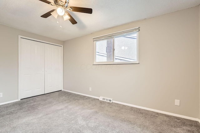unfurnished bedroom with carpet, baseboards, a closet, and a ceiling fan