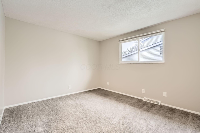 empty room featuring carpet floors, baseboards, and a textured ceiling
