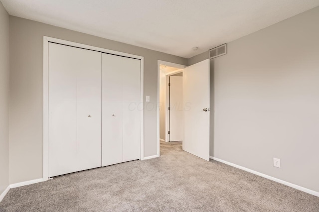 unfurnished bedroom with carpet flooring, baseboards, and a closet