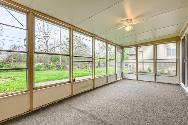 unfurnished sunroom with ceiling fan